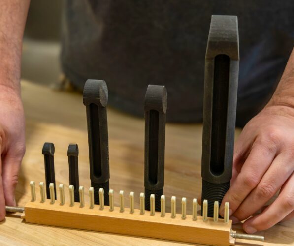 The 3D-printed pegs (back) compared in size to the average-sized loom pegs (front)