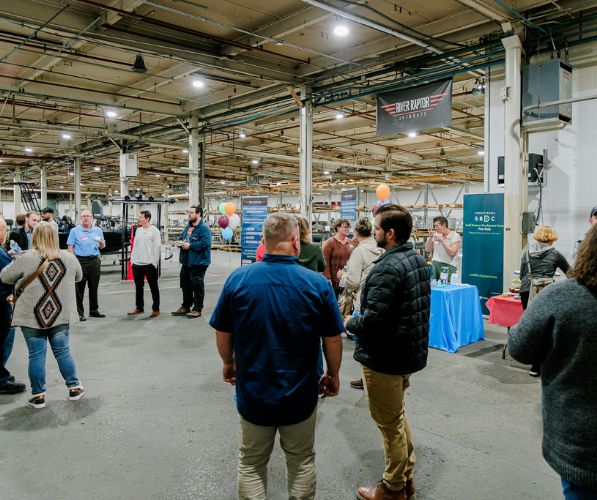 A group of people talking and networking at River Raptor Jet Boats in Belleville, PA