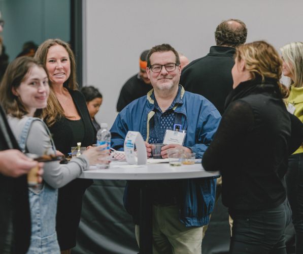 People talking and networking at a table during the Community Networking Event