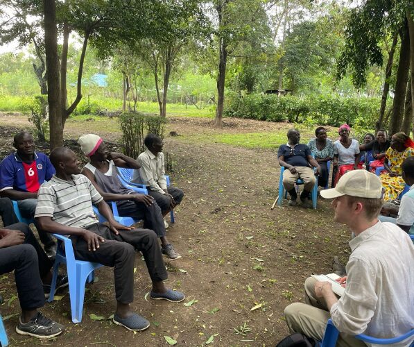 Several individuals sitting together in an outdoor setting having a conversation