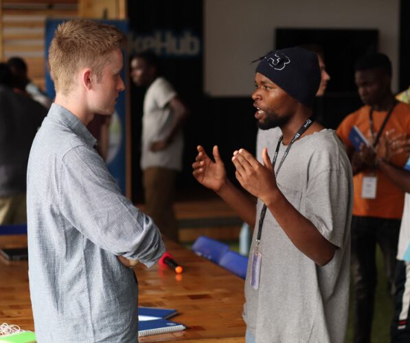 Sam Marshall (left) and a LakeHub Zone01 tech student have a conversation indoors